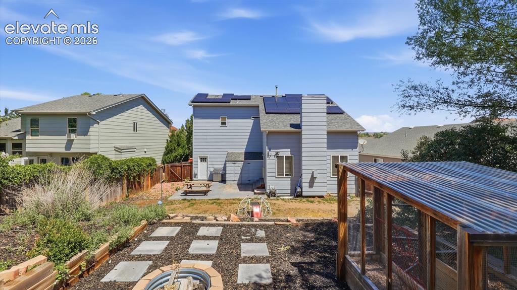 Image 42 of 50: Rear view of home with paid off solar panels for energy savings.