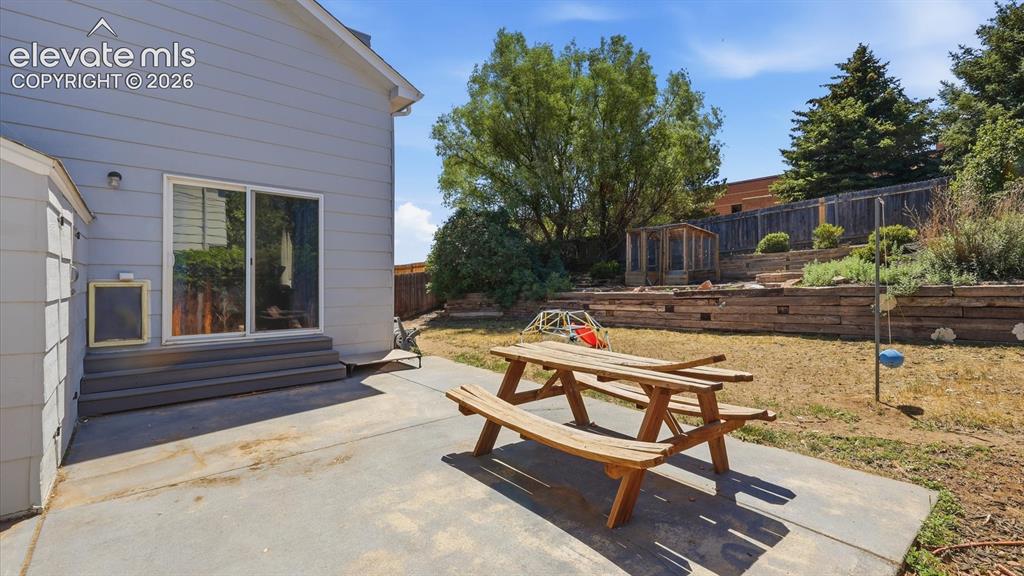 Image 46 of 50: Backyard concrete patio, great for weekend BBQs and family gatherings.