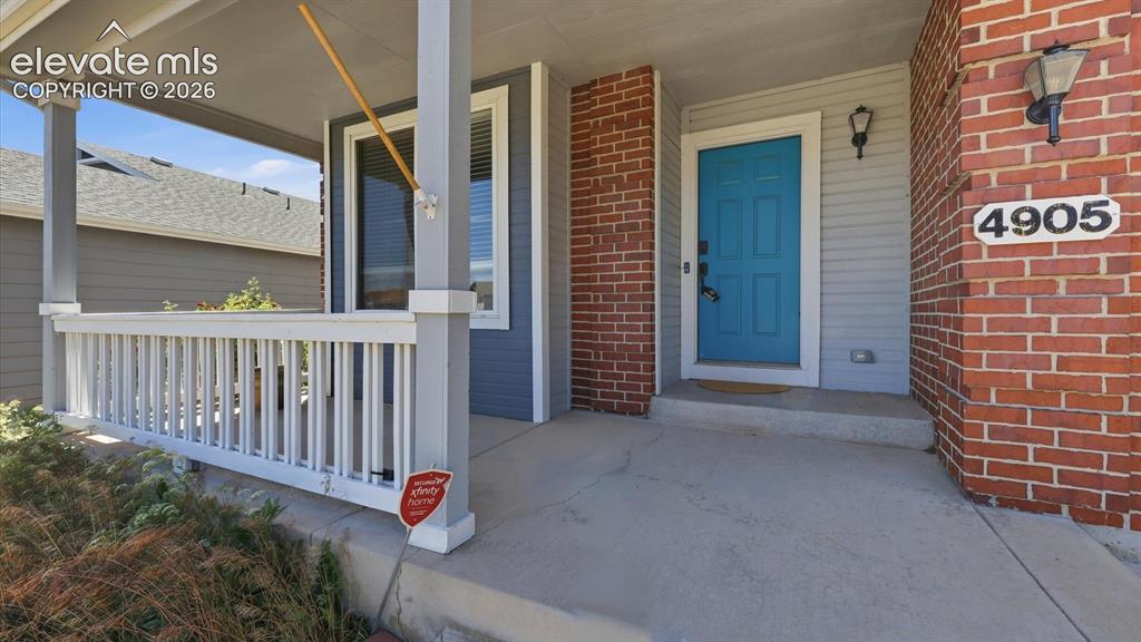 Image 5 of 50: Covered front porch to enjoy the Colorado sunshine.