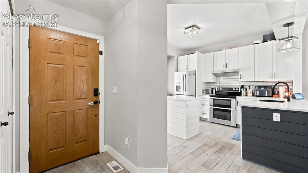 Image 6 of 50: Front Entry into the Kitchen.