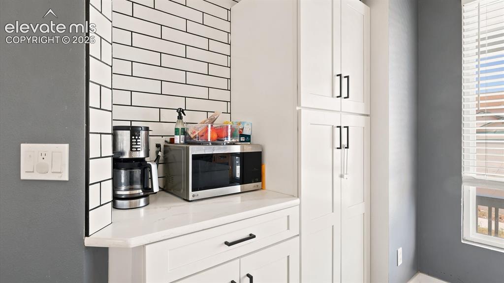 Image 9 of 50: Pantry cabinets with subway tile accent wall.