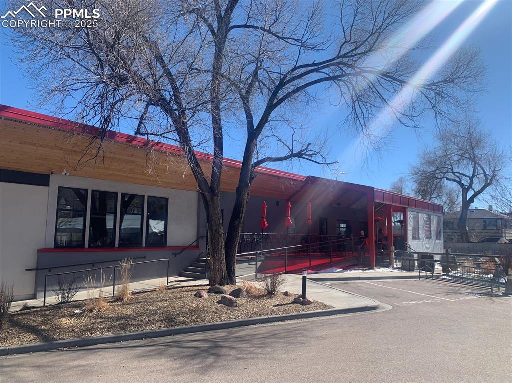 Caption: View of front of home featuring uncovered parking and stucco siding