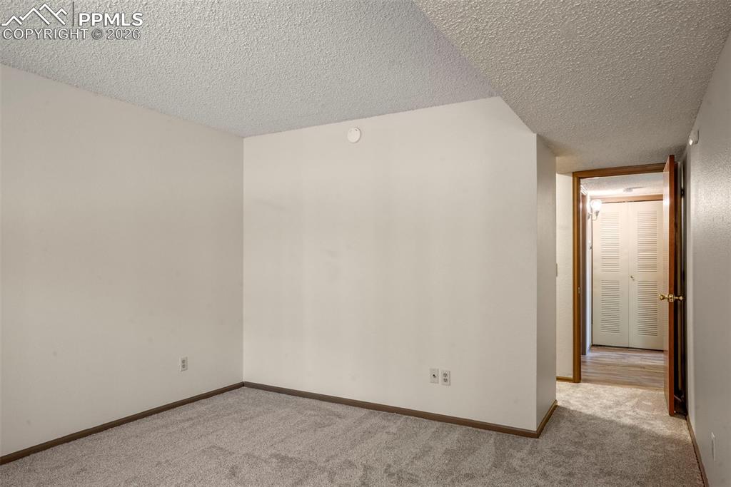Image 13 of 50: Spare room featuring light carpet and a textured ceiling