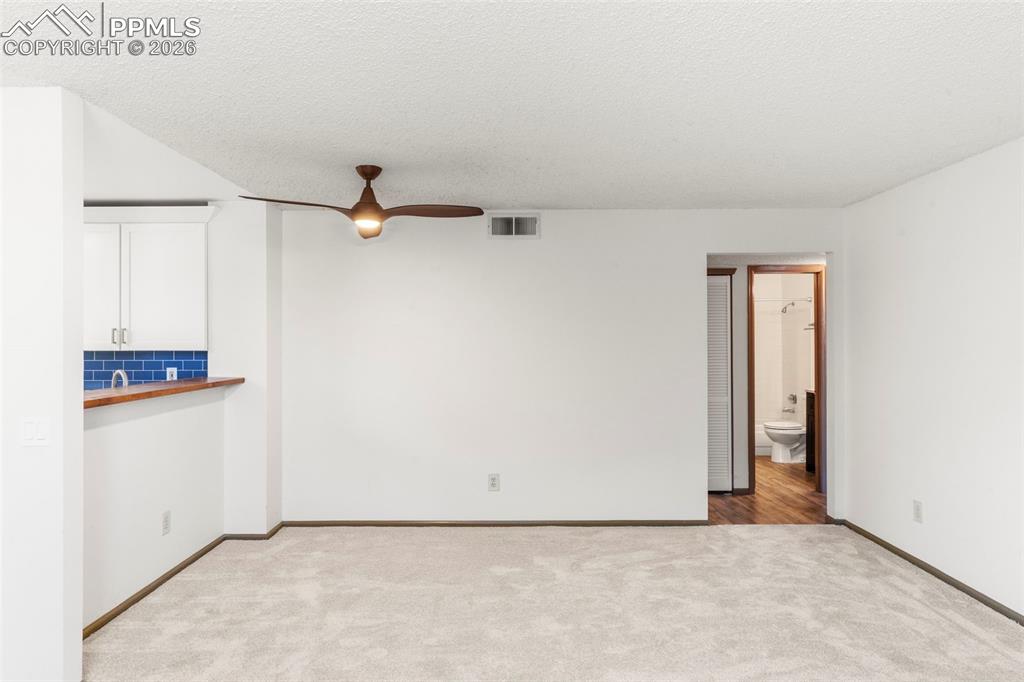 Image 39 of 50: Spare room with light colored carpet, a ceiling fan, and a textured ceiling