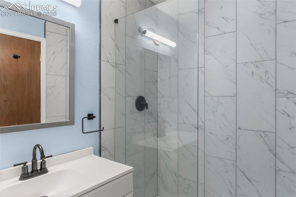Image 45 of 50: 3/4 bathroom featuring vanity and a marble finish WALKIN shower