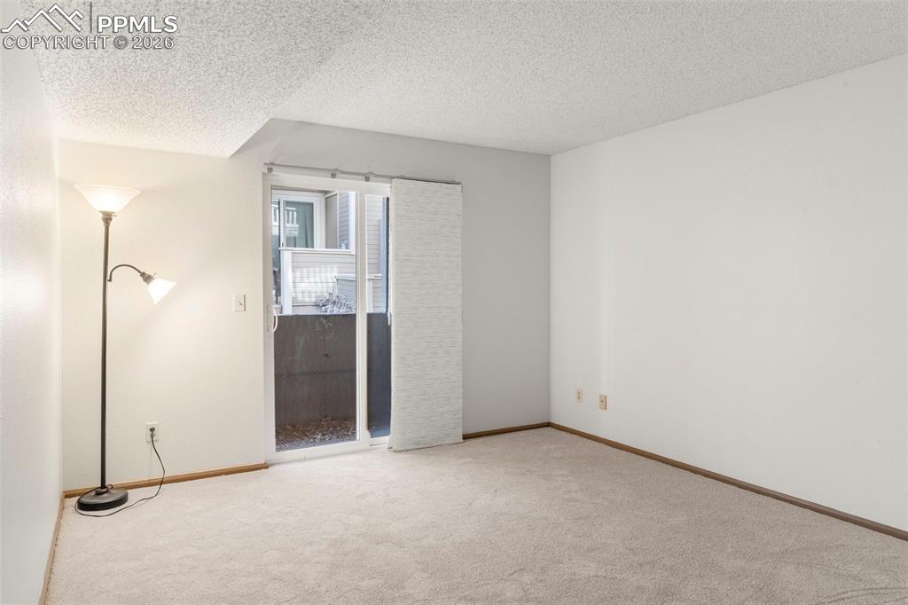 Image 48 of 50: Unfurnished bedroom with a textured ceiling and light carpet