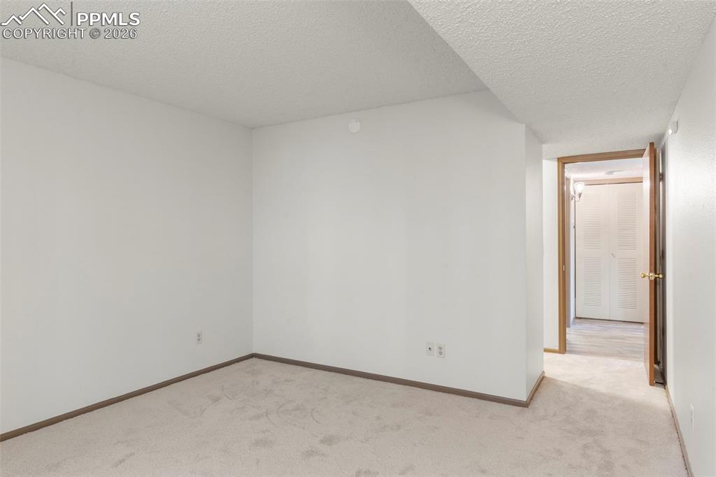Image 49 of 50: Spare room featuring a textured ceiling and light colored carpet