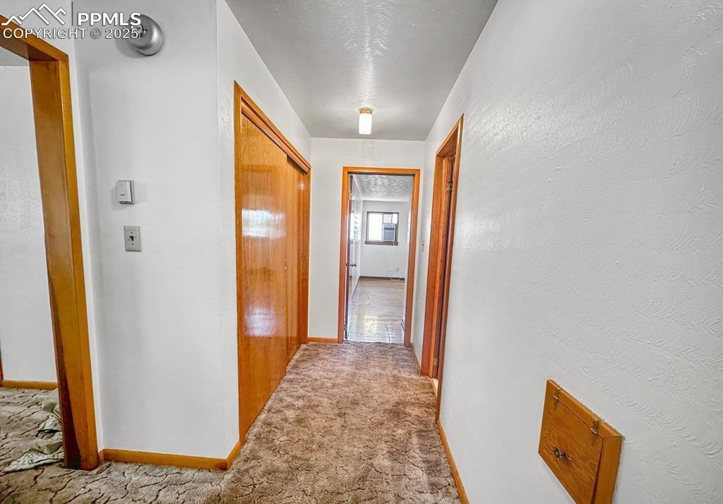 Image 11 of 19: Hall featuring carpet floors and a textured wall