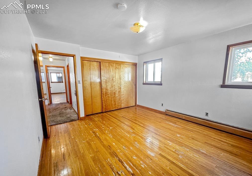 Image 3 of 19: Unfurnished bedroom with light wood-style flooring, multiple windows, a clo