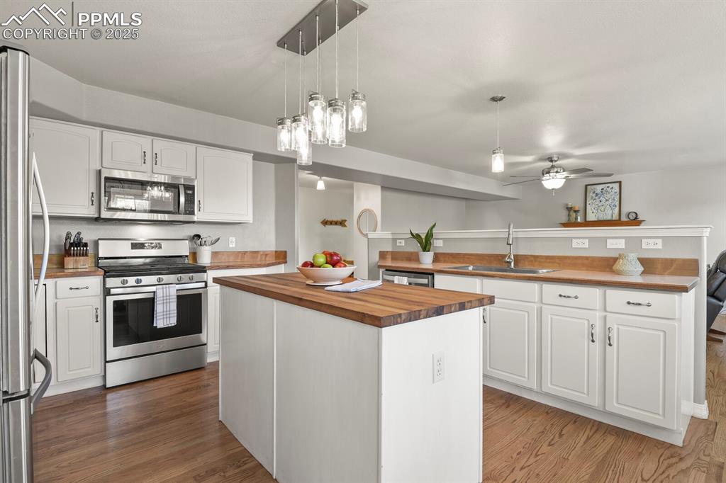 Image 11 of 50: Kitchen with stainless steel appliances, butcher block countertops, a kitch