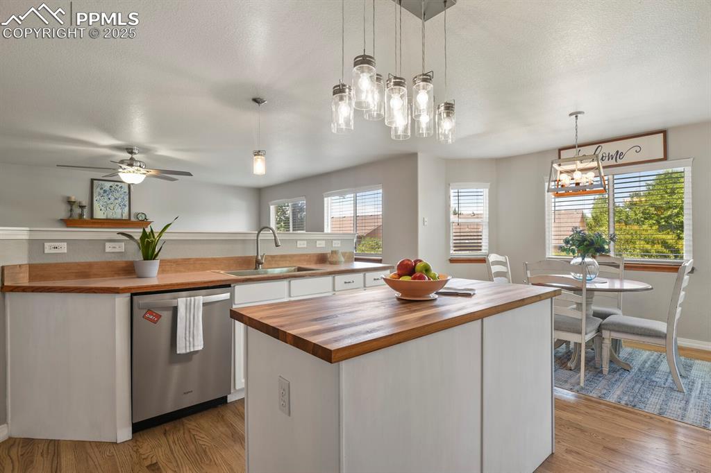 Image 14 of 50: Kitchen featuring butcher block countertops, stainless steel dishwasher, a 