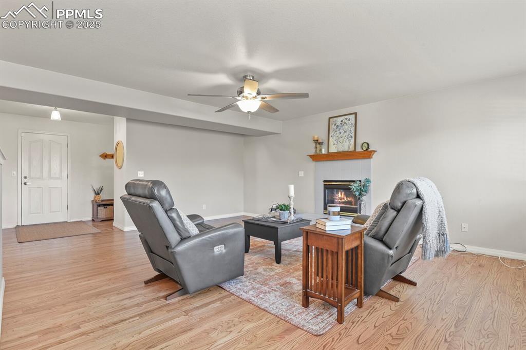 Image 17 of 50: Living area featuring light wood-style floors, a glass covered fireplace, a