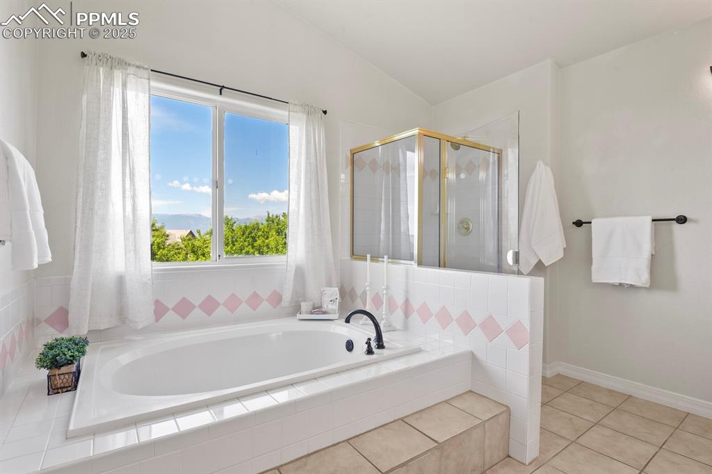 Image 27 of 50: Bathroom featuring a bath, a stall shower, tile patterned floors, and vault