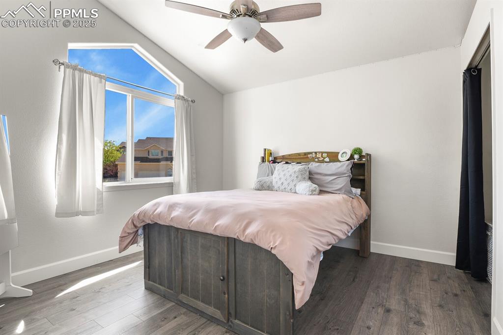 Image 30 of 50: Bedroom featuring lofted ceiling, wood finished floors, and a ceiling fan