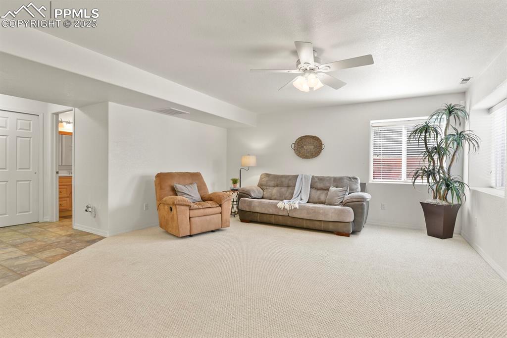 Image 32 of 50: Living area featuring carpet floors and ceiling fan