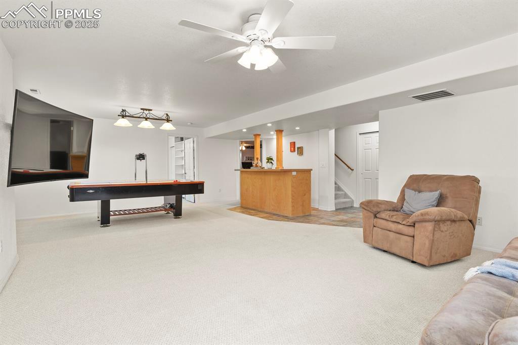 Image 33 of 50: Recreation room with bar, light carpet, billiards, ceiling fan, and recesse