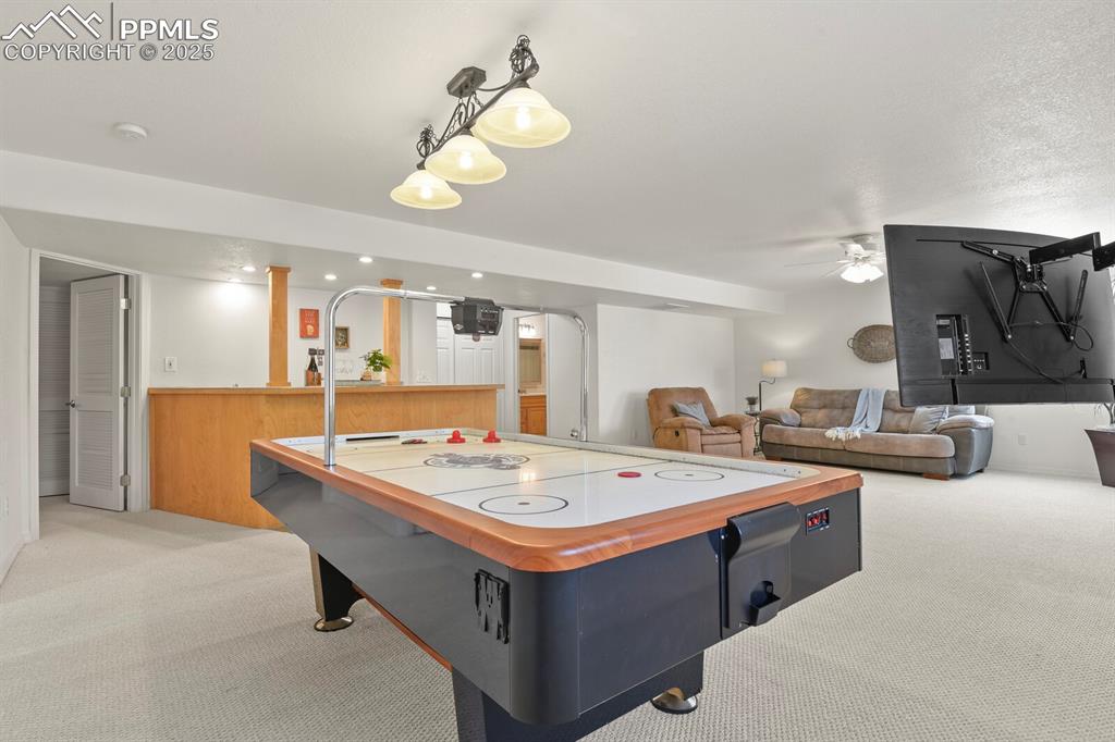 Image 35 of 50: Rec room with light colored carpet and ceiling fan