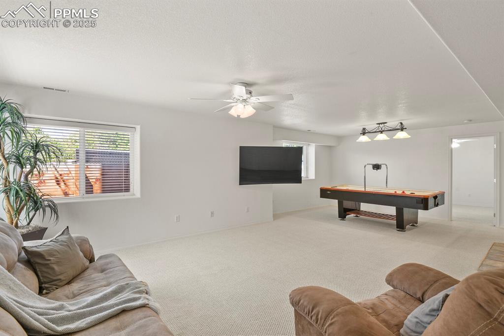 Image 36 of 50: Living room with carpet floors, healthy amount of natural light, ceiling fa