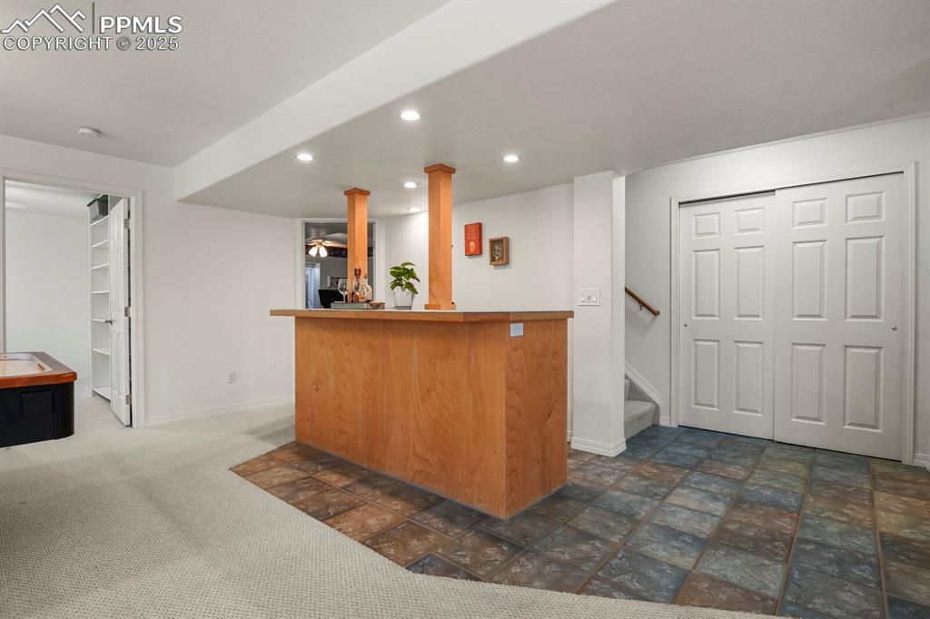 Image 37 of 50: Indoor dry bar with recessed lighting and stairs