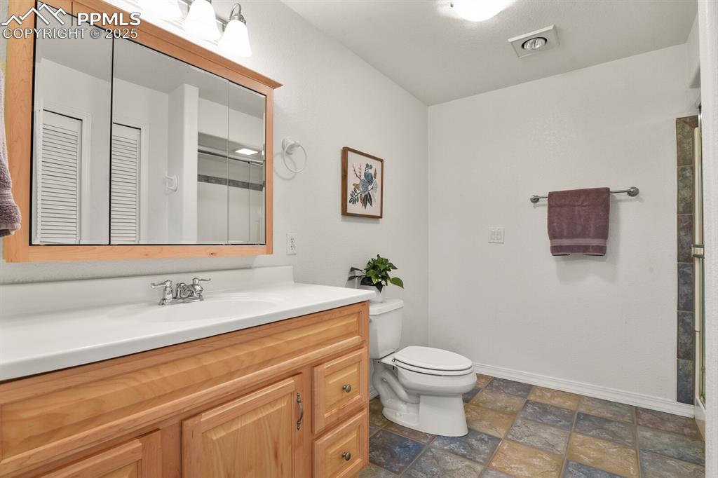 Image 38 of 50: Bathroom featuring vanity and stone finish floors