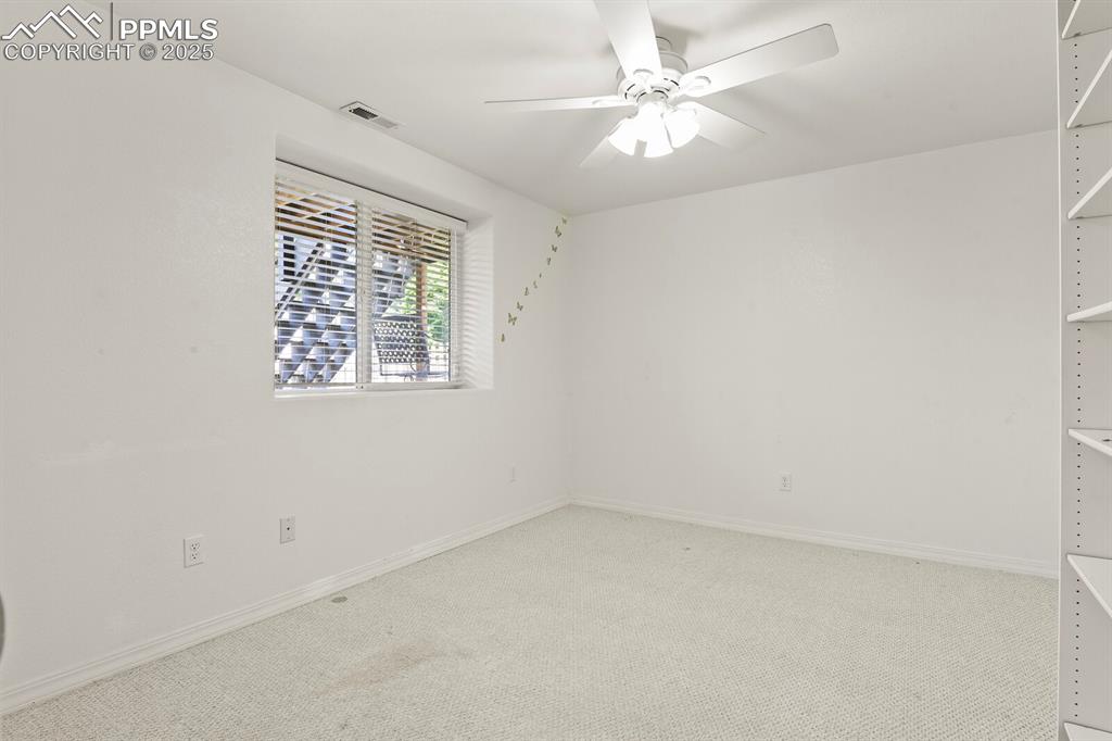 Image 39 of 50: Empty room with light colored carpet and ceiling fan