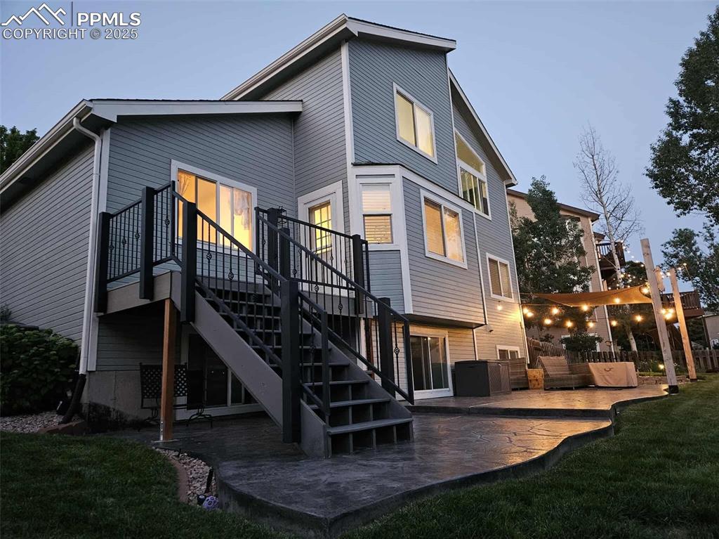 Image 42 of 50: Rear view of property featuring a patio, stairway, and a lawn