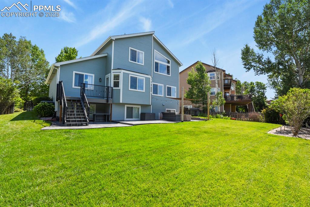 Image 44 of 50: Back of property with stairway, a patio, a deck, and an outdoor living spac