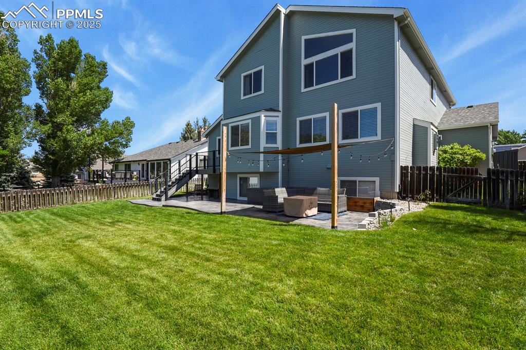 Image 45 of 50: Rear view of house with a patio, a fenced backyard, and stairway