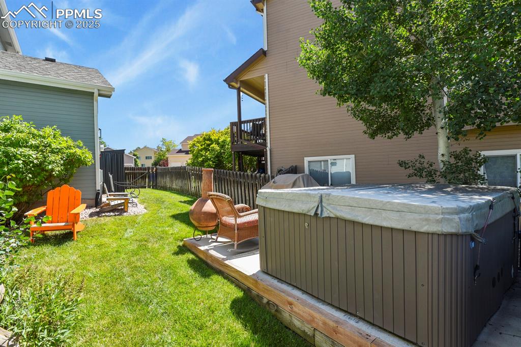 Image 47 of 50: View of yard featuring a hot tub and a deck
