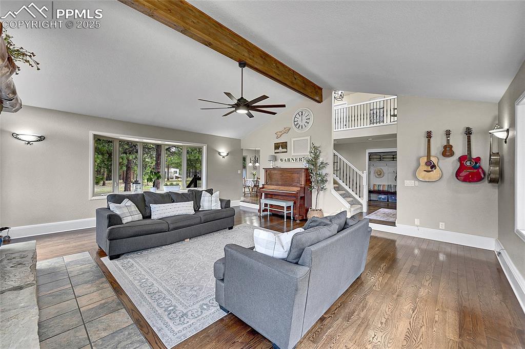 Image 10 of 50: Living room featuring wood finished floors, beamed ceiling, baseboards, hig