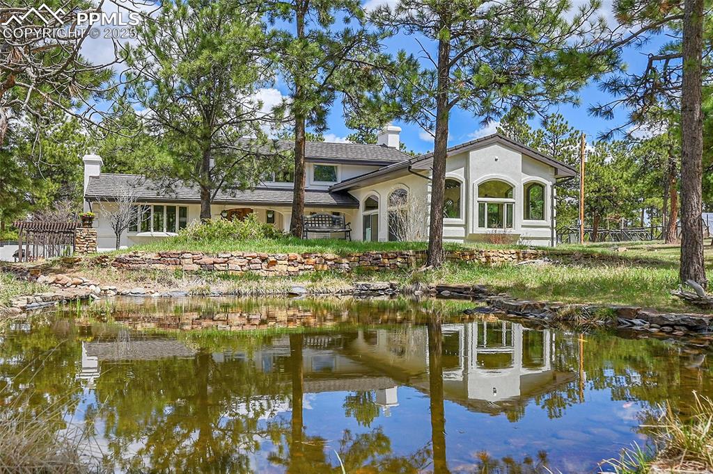 Image 2 of 50: Front of house with view of pond