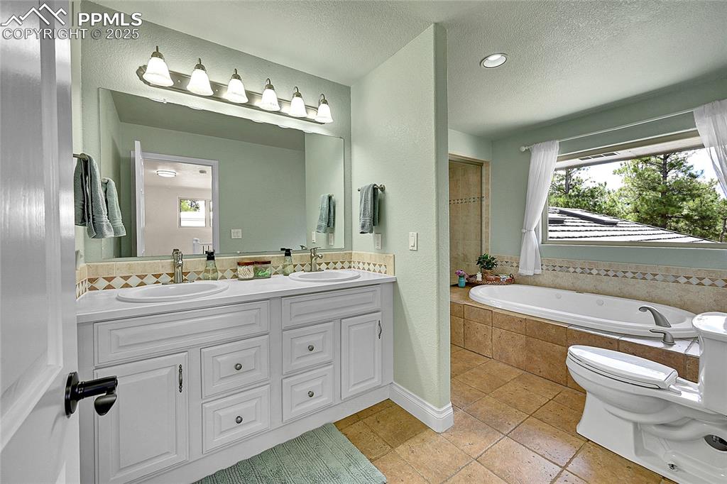 Image 20 of 50: Bathroom with double vanity, jacuzzi tub and enclosed steam shower
