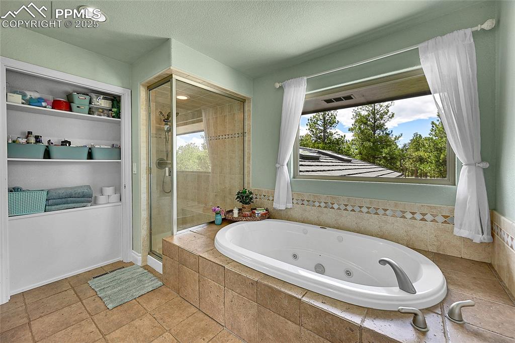 Image 23 of 50: Featuring a jetted tub and steam shower