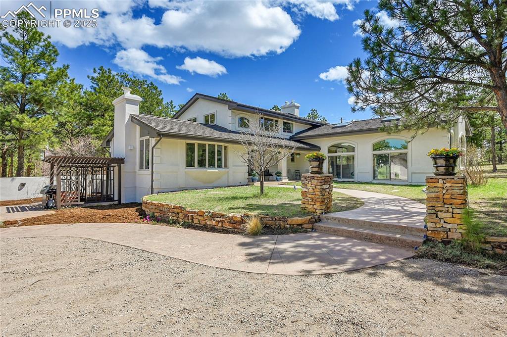 Image 3 of 50: Modern Farmhouse with covered front porch, stucco siding, a pergola,
