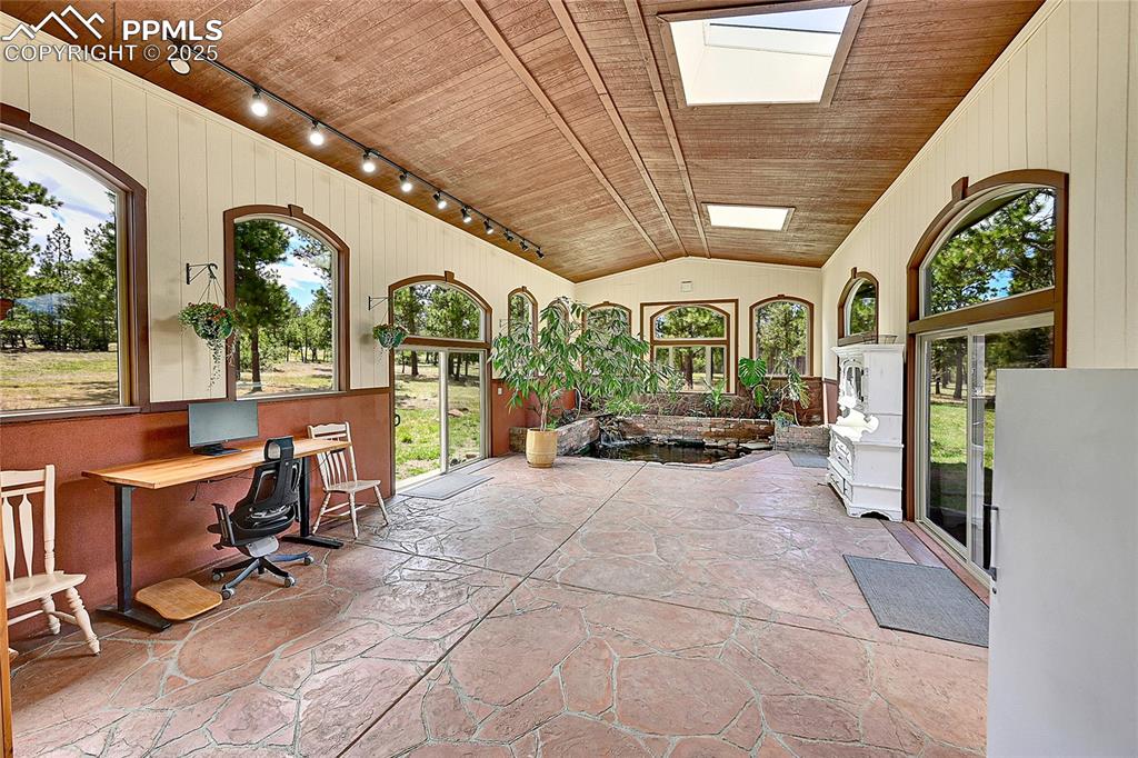 Image 32 of 50: 760 square foot atrium with radiant floor heat and Koi pond with waterfall