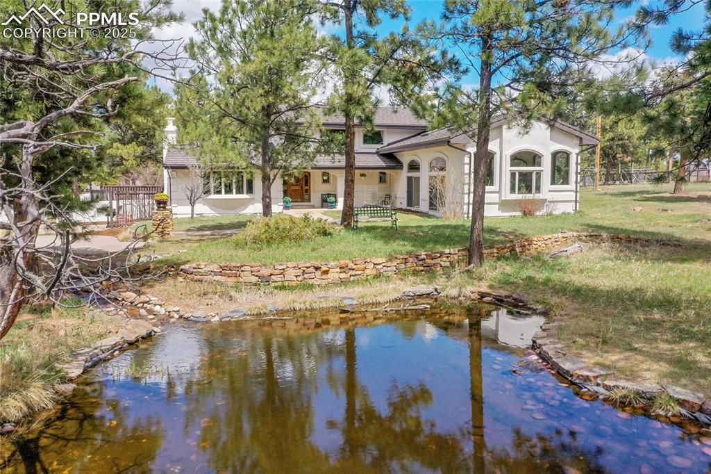 Image 39 of 50: Home surrounded by towering pines