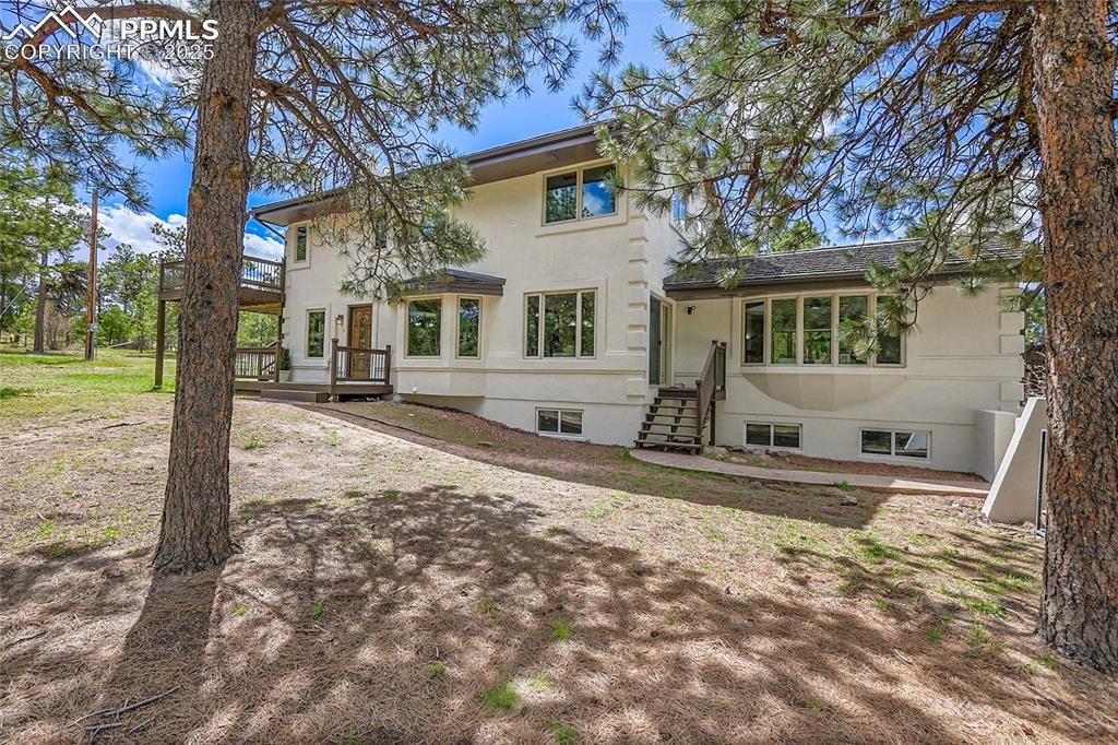 Image 42 of 50: View of front of property with a wooden deck and stucco siding