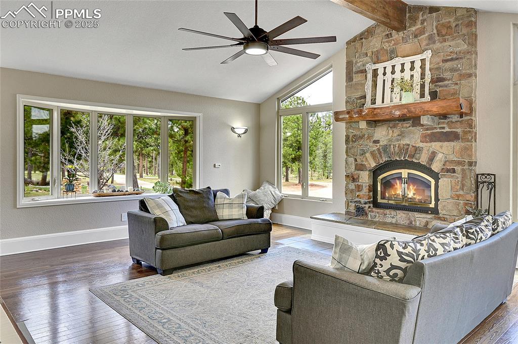 Image 7 of 50: Great room living area featuring beamed vaulted ceilings 2 story fireplace 