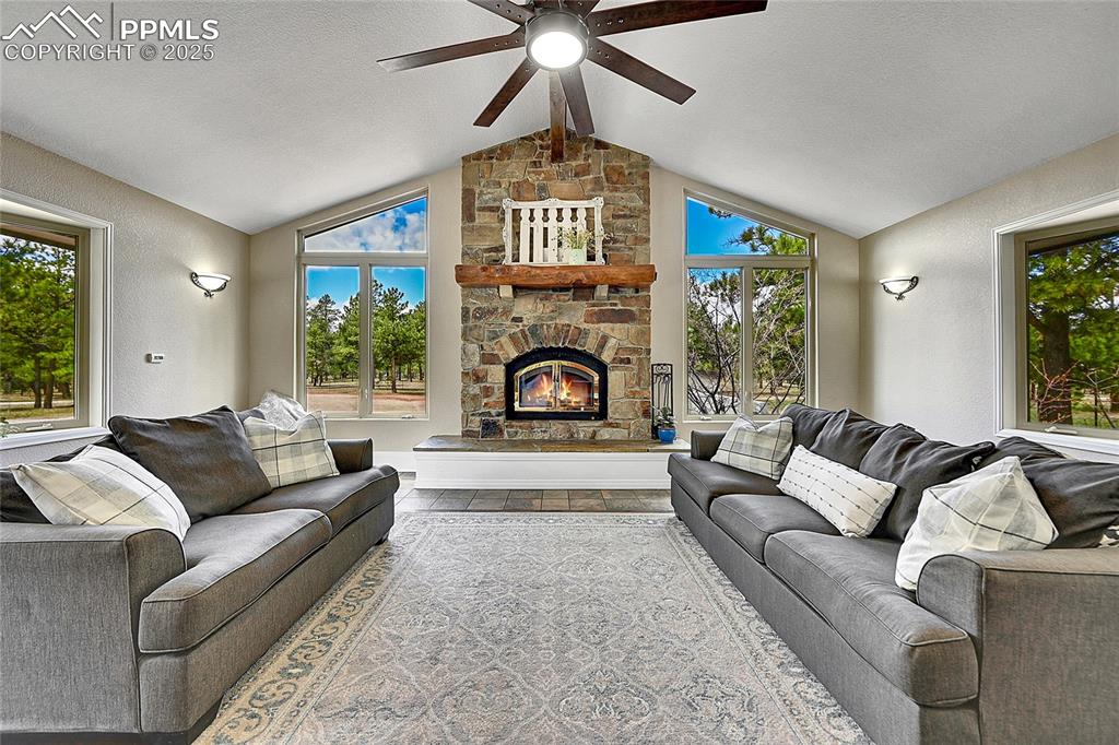 Image 8 of 50: Living area featuring views of surrounding pines with floor to ceiling wind