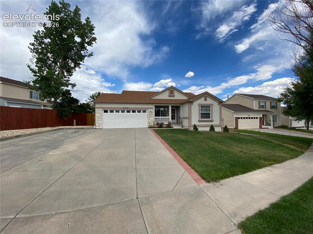 Caption: Ranch-style exterior with a stone veneer facade, a two-car garage, and a covered porch entry