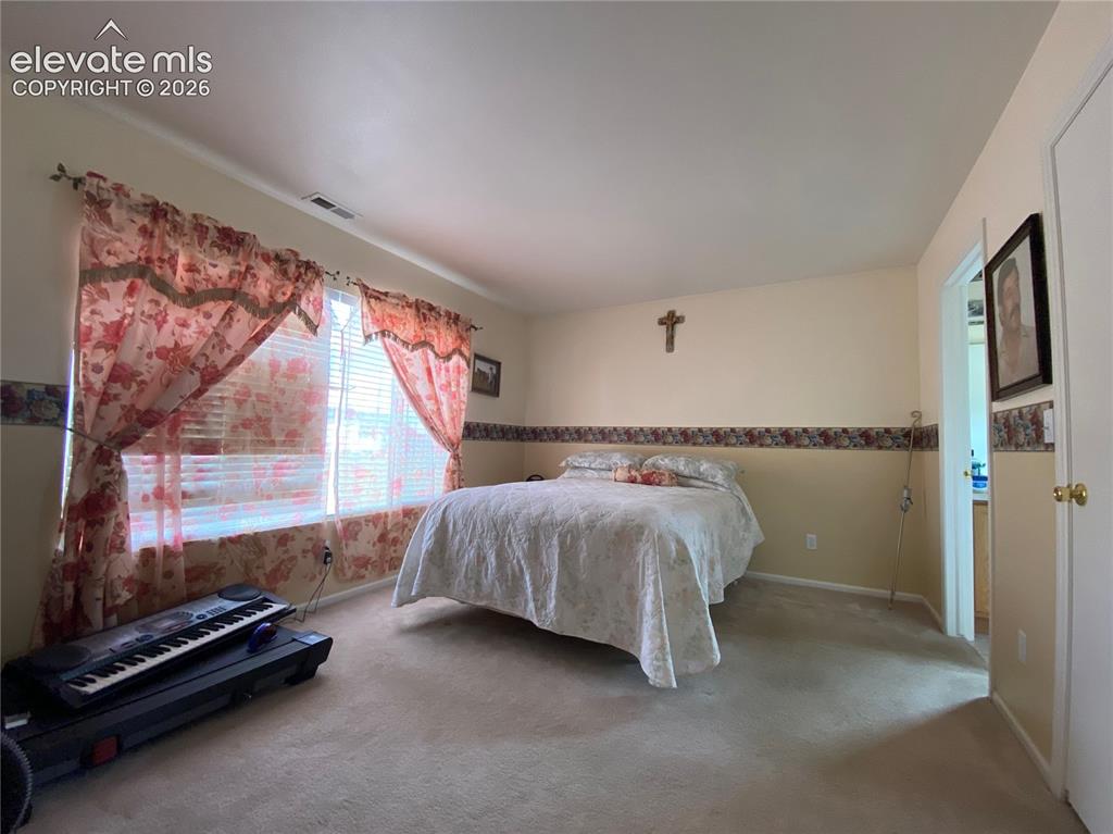 Image 3 of 9: Carpeted interior room with a window featuring horizontal blinds
