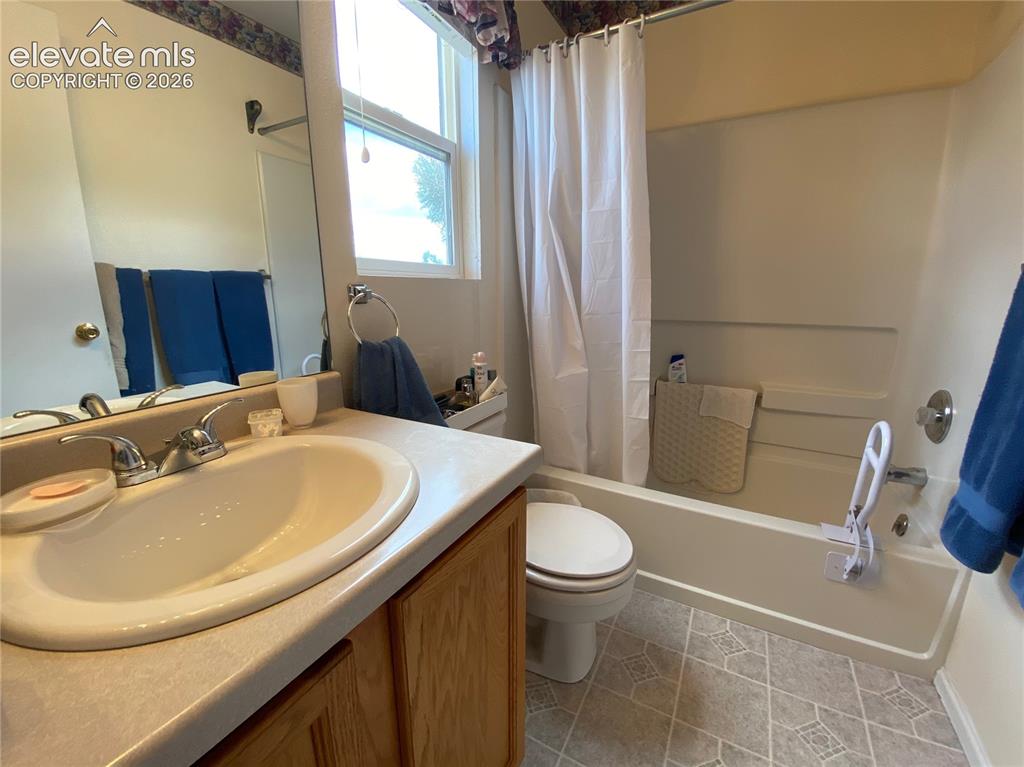 Image 4 of 9: Bathroom featuring a vanity with an integrated sink, a large wall-mounted m