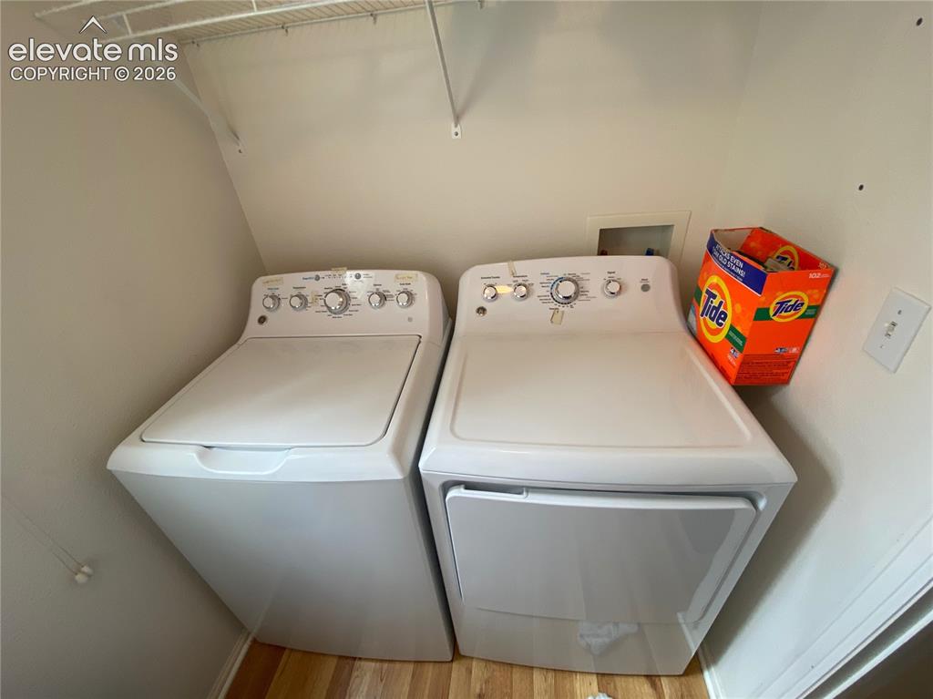 Image 8 of 9: Dedicated laundry area featuring a white top-load washer and front-load dry