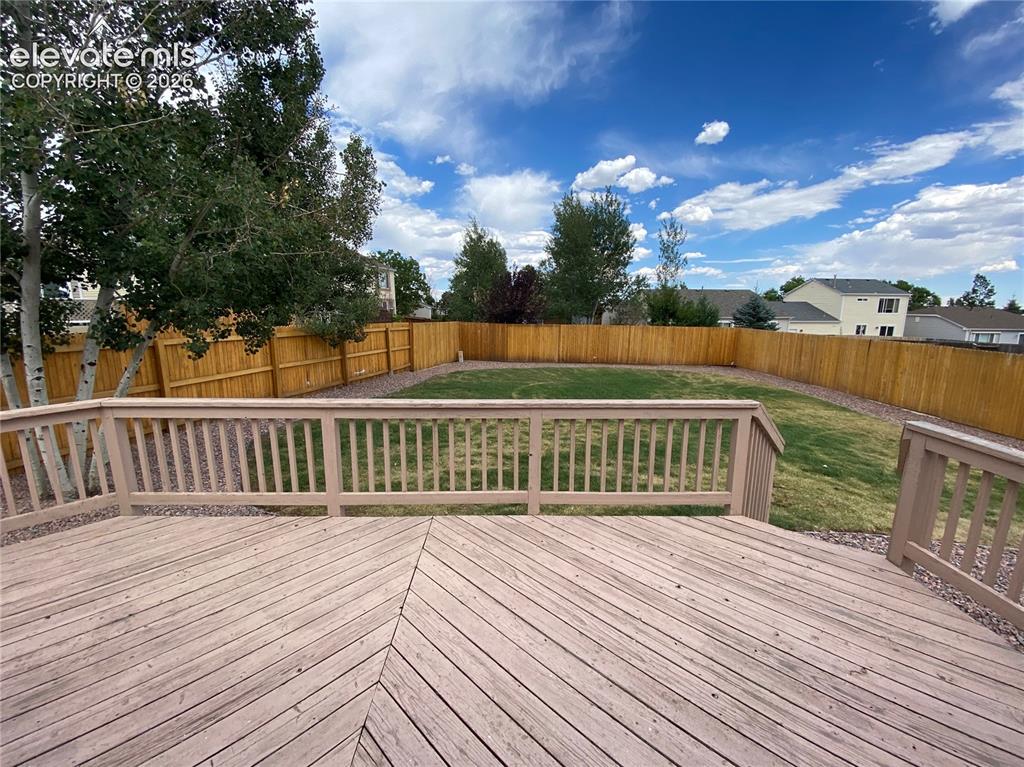Image 9 of 9: Spacious wood-finish deck featuring a geometric plank pattern and light-ton