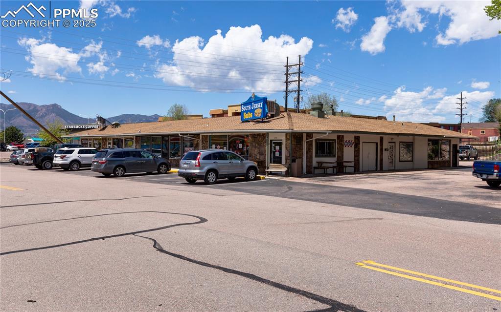 Caption: View of building exterior featuring uncovered parking