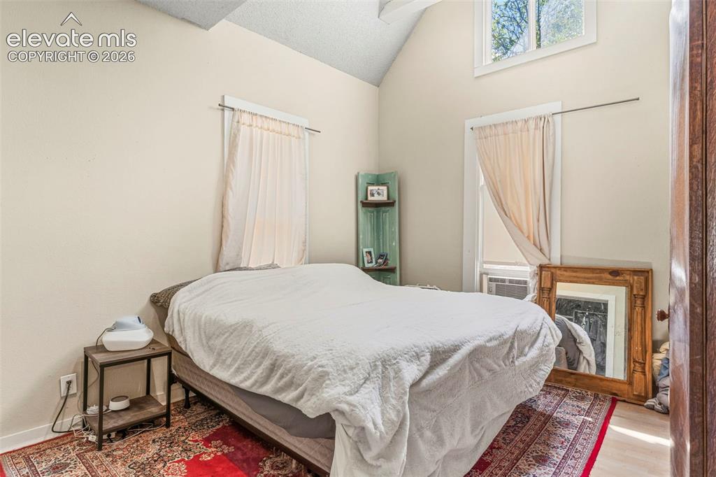 Image 15 of 25: The primary bedroom features an adjoining bathroom and wood laminate floori
