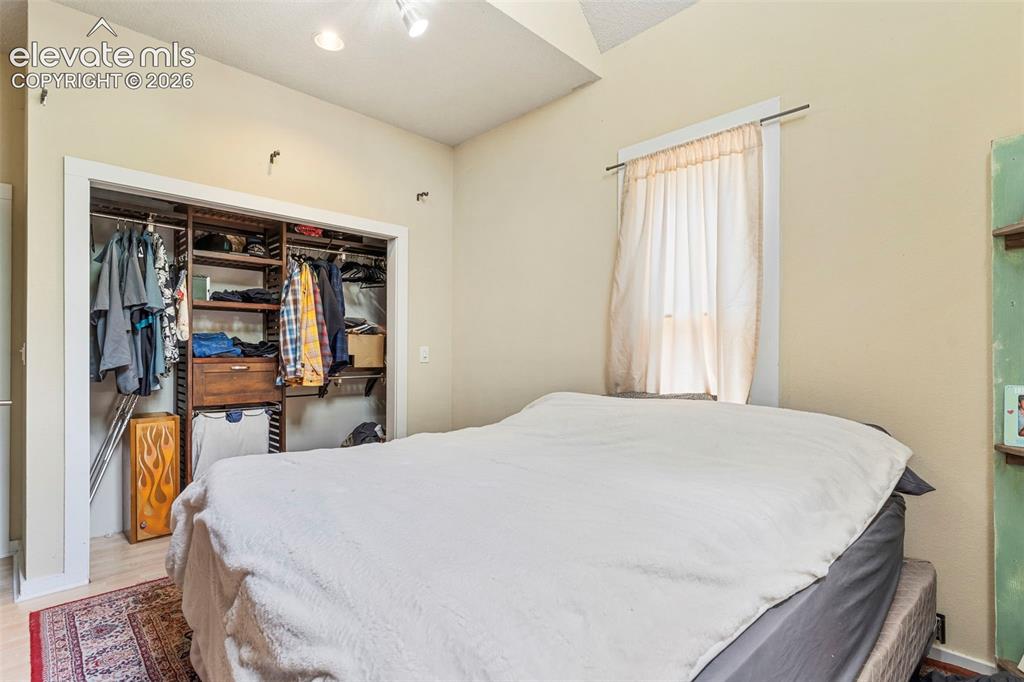 Image 16 of 25: The primary bedroom featuring large closet with built-in shelving.