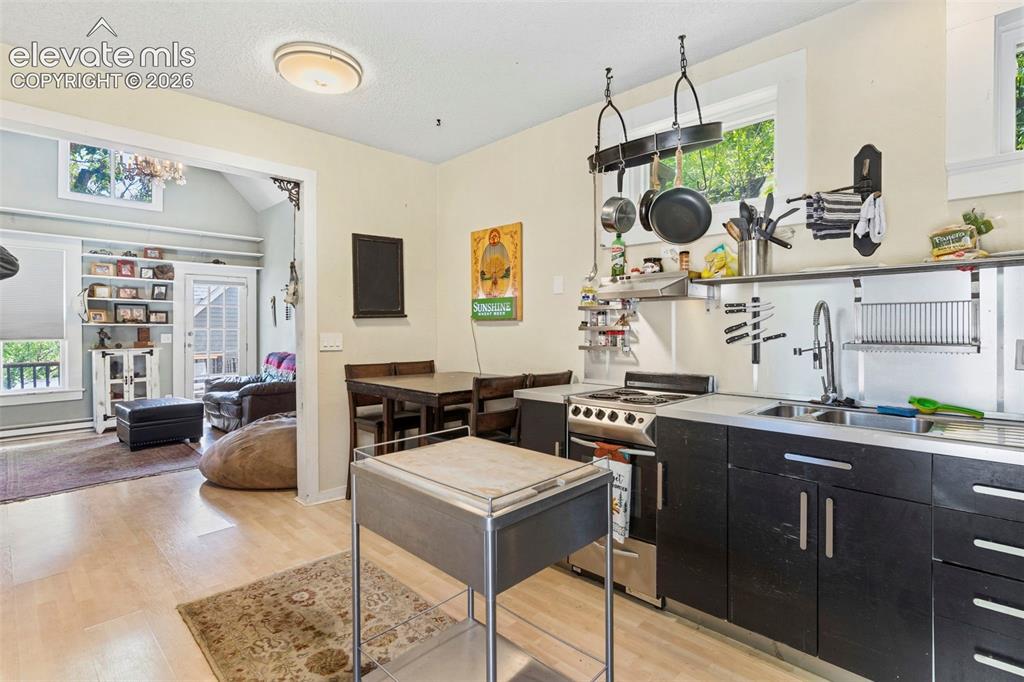 Image 6 of 25: A modern industrial-style kitchen with an attached dining area.
