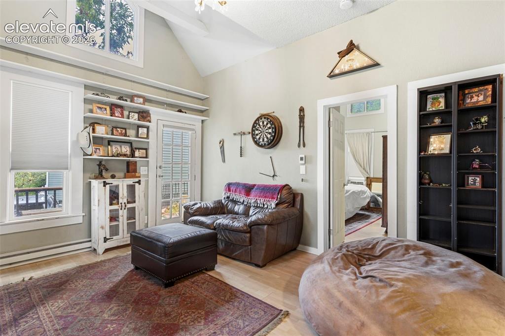 Image 9 of 25: A spacious living room with built-in shelving and a walkout to the deck.
