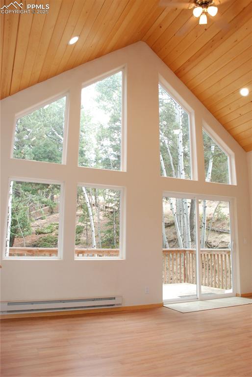 Image 6 of 37: Soaring wood finished cathedral ceilings and new wood laminate floors are a